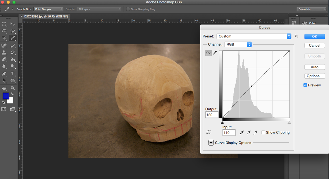 Image of a carved, wooden skull being edited using the curves tool in Photoshop