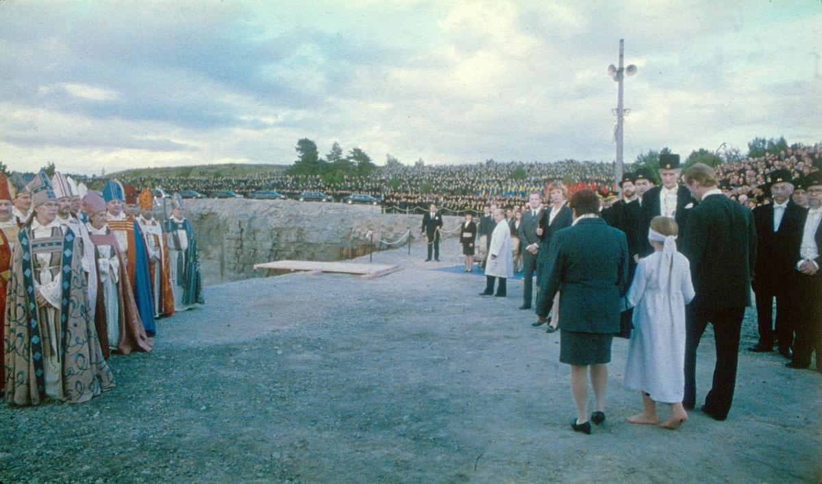 Religious leaders, schoolteachers, learned men, and the masses watch as a young girl’s parents lead her to the edge of a cliff and push her off in a scene titled The Sacrifice in Sånger från andra våningen Songs from the Second Floor (2000) Photo courtesy of Studio 24. Religious leaders, schoolteachers, learned men, and the masses watch as a young girl’s parents lead her to the edge of a cliff and push her off in a scene titled The Sacrifice in Sånger från andra våningen Songs from the Second Floor (2000) Photo courtesy of Studio 24.